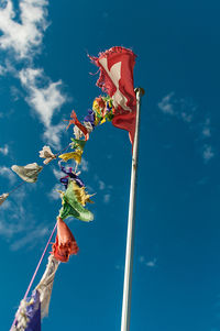 Low angle view of flag against blue sky