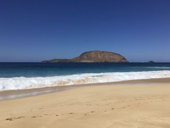 Scenic view of beach against clear sky