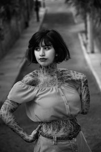 Beautiful young woman looking away standing on road