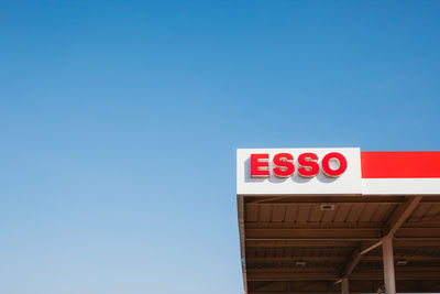 Low angle view of sign against clear blue sky