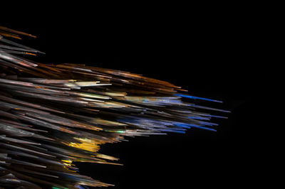 Low angle view of illuminated lighting equipment against black background