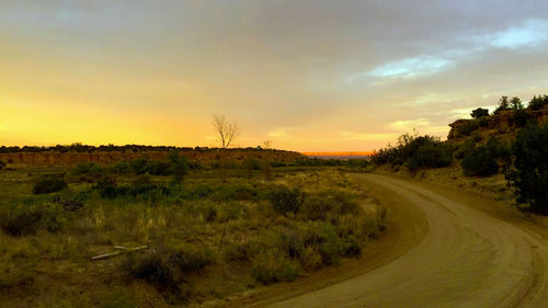 Scenic view of field against sky at sunset