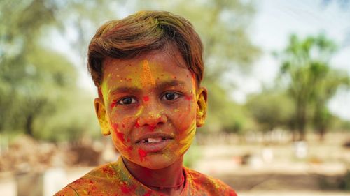 Portrait of little boy playing with colors. holi concept. child covered in colored powder during the