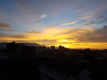 Silhouette buildings against sky during sunset