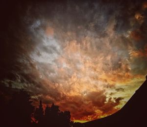 Silhouette of trees against dramatic sky