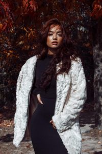 Close-up portrait of young woman in warm clothing standing outdoors during autumn