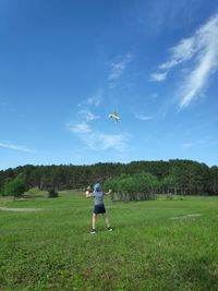 Full length of person paragliding on field against sky