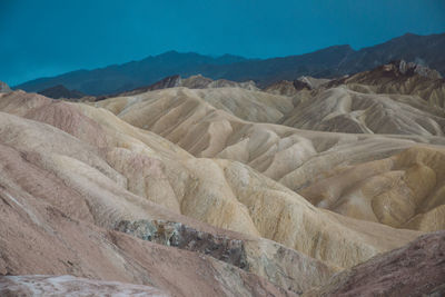 Scenic view of eroded landscape against cloudy sky at death valley national park