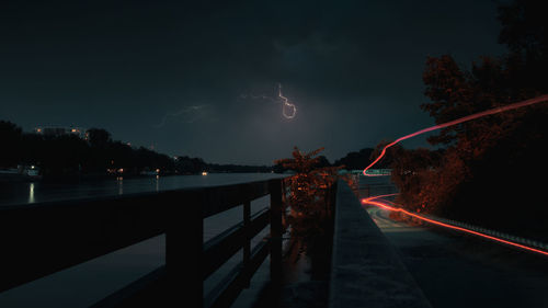 Lightning over illuminated mountain against sky at night