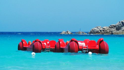 Pedal boats moored in sea