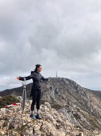 A woman standing on the peak of the mountain 