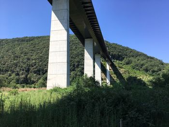 Low angle view of bridge against clear blue sky