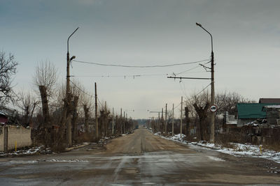 Road amidst trees against sky during winter