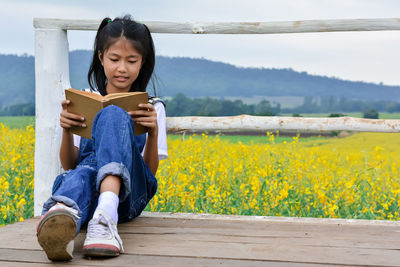 Full length of girl sitting on field