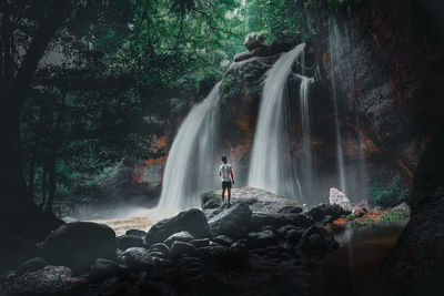 Woman standing on rock in forest