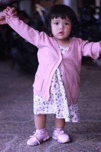 Portrait of cute girl standing with pink petals