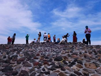 Low angle view of people standing on beach