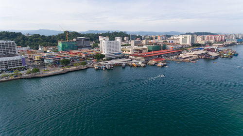 High angle view of buildings by sea against sky