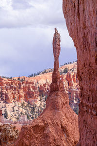 Rock formations on landscape against cloudy sky