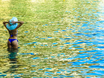 Rear view of woman standing in lake