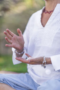 Female crystal healing therapist meditating, manifesting abundance with white selenite crystal