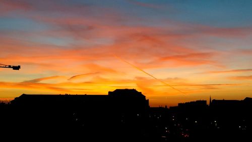 Silhouette buildings against sky during sunset