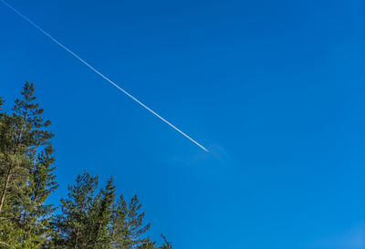 Low angle view of vapor trail against clear blue sky