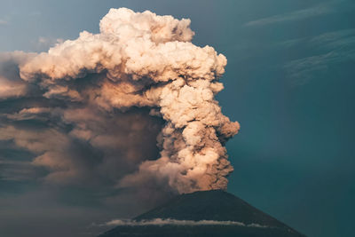 Smoke emitting from volcanic mountain against sky