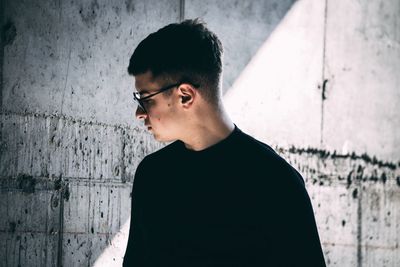 Close-up of young man standing against wall