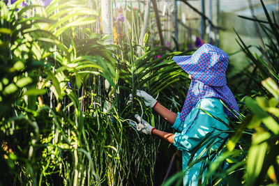 Rear view of woman standing by plants