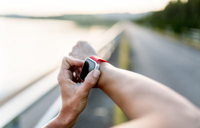 Woman adjustung settings of smart watch for outdoor training