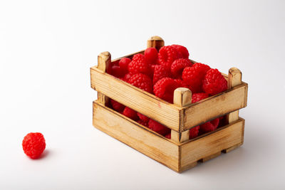 Close-up of strawberries in box against white background