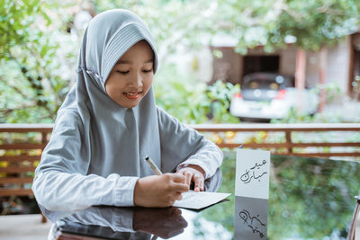 Portrait of young woman reading book