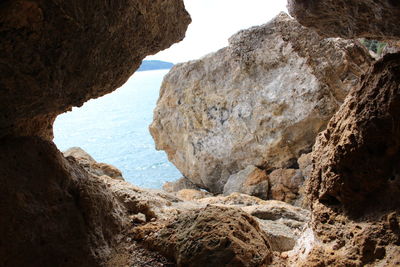 Rock formations by sea against sky