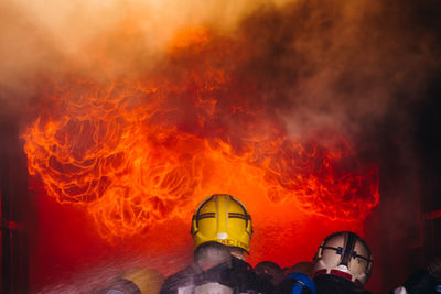 Rear view of firefighters extinguishing fire 