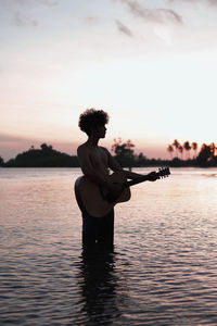 Playing guitar on the beach at sunset