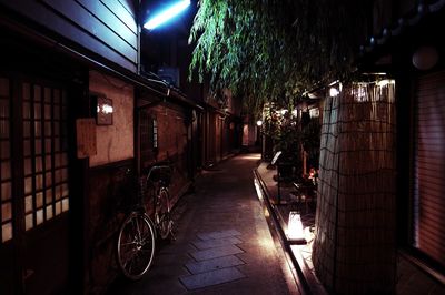 Illuminated walkway in city at night