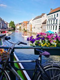 Scenic view of river by buildings against sky