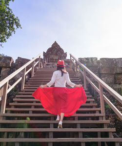 Woman climbing stairs towards temple