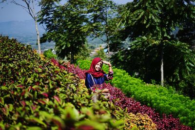 Woman with pink flowers in garden