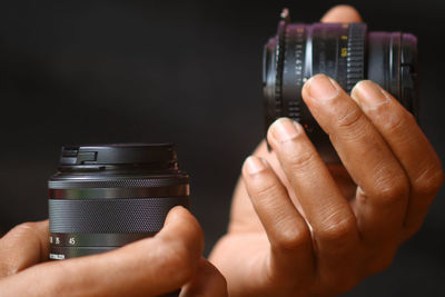 Cropped hands of person holding lens