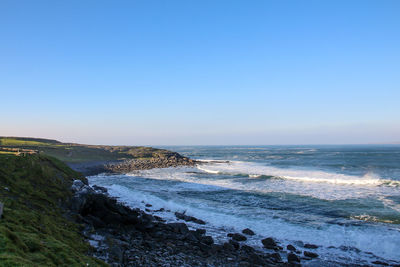 Scenic view of sea against clear blue sky