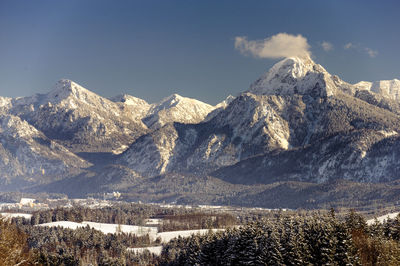 Panorama of snow covered mountains against blue sky