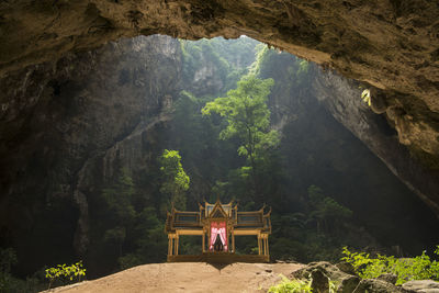 People relaxing on rock in cave