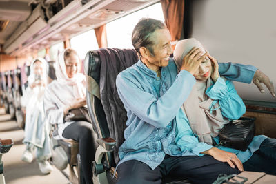 Young woman using mobile phone while sitting in bus