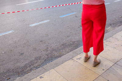 Low section of woman standing on road