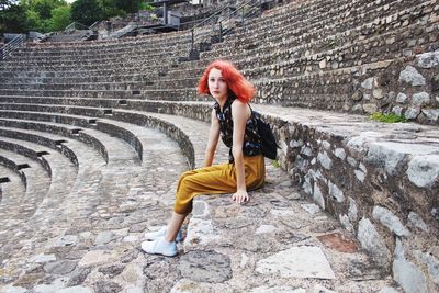 Woman sitting on steps at amphitheater