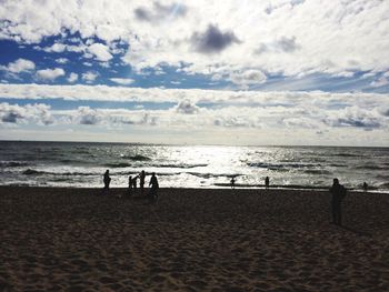 People standing on beach against sky