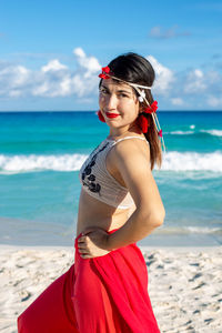 Portrait of beautiful young woman standing on beach