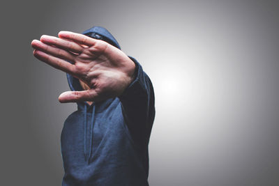 Midsection of man holding hands against white background